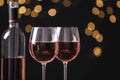 Glasses and bottle with delicious rose wine  blurred lights, closeup. Space for text Royalty Free Stock Photo