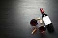 Glasses and bottle with red wine on dark background, flat lay Royalty Free Stock Photo