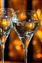 Glasses of brut champagne bubbles wine in tulip glass on evening bar lights background Royalty Free Stock Photo