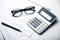 Glasses and calculator on paper table with finance report Royalty Free Stock Photo