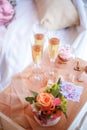 Glasses with champagne, cake, flowers, wooden key and tapes on the bedside table Royalty Free Stock Photo