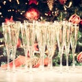 Glasses of champagne with Christmas tree background. Many glasses for party. Holiday season background. Traditional red and green Royalty Free Stock Photo