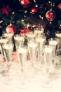 Glasses of champagne with Christmas tree background. Many glasses for party. Holiday season background. Traditional red and green Royalty Free Stock Photo