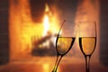 Glasses of champagne in front of warm fireplace Royalty Free Stock Photo