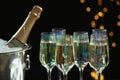 Glasses of champagne and ice bucket with bottle on black background Royalty Free Stock Photo