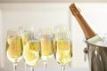 Glasses of champagne and ice bucket with bottle on blurred background Royalty Free Stock Photo