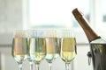 Glasses of champagne and ice bucket with bottle on blurred background Royalty Free Stock Photo