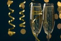 Glasses of champagne and serpentine streamer on dark blue background with blurred lights, closeup Royalty Free Stock Photo