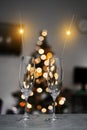 Glasses of champagne, sparklers on the background of a Christmas tree and garlands. happy holidays. Merry Christmas Royalty Free Stock Photo