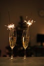Glasses of champagne, sparklers on the background of a Christmas tree and garlands. happy holidays. Merry Christmas Royalty Free Stock Photo