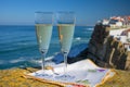 Glasses of champagne sparkling wine and view on white houses of picturesque village Azenhas do mar, Lisbon area, Portugal Royalty Free Stock Photo