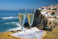 Glasses of champagne sparkling wine and view on white houses of picturesque village Azenhas do mar, Lisbon area, Portugal Royalty Free Stock Photo