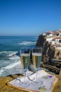 Glasses of champagne sparkling wine and view on white houses of picturesque village Azenhas do mar, Lisbon area, Portugal Royalty Free Stock Photo