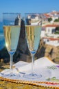 Glasses of champagne sparkling wine and view on white houses of picturesque village Azenhas do mar, Lisbon area, Portugal Royalty Free Stock Photo