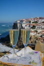 Glasses of champagne sparkling wine and view on white houses of picturesque village Azenhas do mar, Lisbon area, Portugal Royalty Free Stock Photo