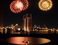 Glasses of champagne on a table with fireworks in the background