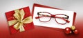 Glasses christmas gift card, red box with shiny golden ribbon bow, white ticket and eyewear near xmas balls on glittering red
