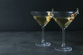 Glasses of Classic Dry Martini with olives on dark table against black background. Royalty Free Stock Photo