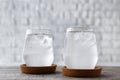 Glasses of clean water and ice cubes on wooden table Royalty Free Stock Photo