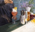 Glasses of cocktails on the bar. Bartender pours a glass of sparkling wine with red alcohol Royalty Free Stock Photo