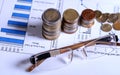 Glasses and coins on financial graphics Royalty Free Stock Photo