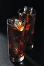 Glasses of cola with ice cubes on black stone Royalty Free Stock Photo