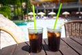 Glasses with cola and ice at the pool on summer holidays