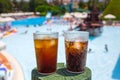 Glasses with cola and ice at the pool