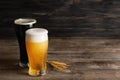 Glasses with cold beer and spikelets on wooden table