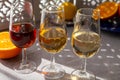 Glasses with cold dry fino and sweet cream sherry fortified wine and orange in sunlights, andalusian style interior on background Royalty Free Stock Photo