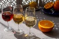 Glasses with cold dry fino and sweet cream sherry fortified wine and orange in sunlights, andalusian style interior on background Royalty Free Stock Photo