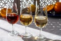 Glasses with cold dry fino and sweet cream sherry fortified wine and orange in sunlights, andalusian style interior on background