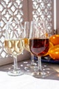 Glasses with cold dry fino and sweet cream sherry fortified wine and orange in sunlights, andalusian style interior on background Royalty Free Stock Photo