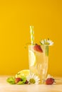 Glasses of cold icy refreshing drink with lemon and strawberry. Bright yellow background.  Fresh cocktail drinks with ice fruit, Royalty Free Stock Photo