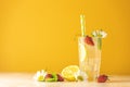 Glasses of cold icy refreshing drink with lemon and strawberry. Bright yellow background. Fresh cocktail drinks with ice fruit, Royalty Free Stock Photo