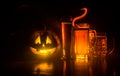 Glass of cold light beer with pumpkin on a wood background for Halloween. Glass of fresh beer and pumpkin on a dark toned foggy Royalty Free Stock Photo