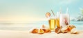 Glasses with cold refreshing summer drinks. Ice lemonade and tea on sand beach with shells over blue water and sky background. Royalty Free Stock Photo