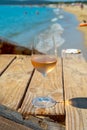 Glasses of cold rose wine from Provence served outdoor on wooden yacht pier with view on blue water and white sandy beach Plage de