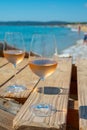 Glasses of cold rose wine from Provence served outdoor on wooden yacht pier with view on blue water and white sandy beach Plage de