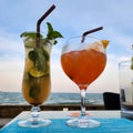 glasses with colored alcoholic cocktails stand on the table against the backdrop of the sea