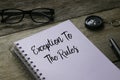 Glasses,compass,pen and notebook written with Exception to the rules on wooden background