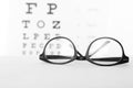 Glasses with corrective lenses on table against eye Royalty Free Stock Photo