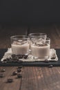 Glasses of Cream coffee liqueur with ice, and coffee  beans on rustic wooden background Royalty Free Stock Photo