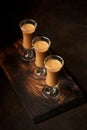 Glasses of creamy liqueur on dark background