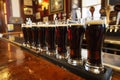glasses of dark beer lined up on a bar with traditional pub decor Royalty Free Stock Photo