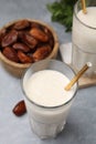 Glasses of delicious date smoothie and dried fruits on light grey table Royalty Free Stock Photo