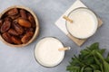 Glasses of delicious date smoothie, dried fruits and mint on light grey table, flat lay Royalty Free Stock Photo