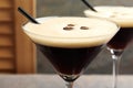 Glasses of delicious espresso martini with coffee beans on table, closeup Royalty Free Stock Photo