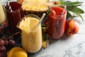 Glasses of delicious juices and fresh ingredients on white marble table, closeup Royalty Free Stock Photo