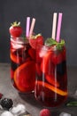 Glasses of delicious refreshing sangria, ice cubes and berries on grey table Royalty Free Stock Photo
